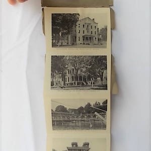 Może przedstawiać: Zabytkowa czarno-biała poczt&oacute;wka z czterema historycznymi zdjęciami. Zdjęcia przedstawiają budynki i konstrukcje, prawdopodobnie z dawnej epoki. Poczt&oacute;wka jest trzymana otwarta przez dłoń, odsłaniając zdjęcia.