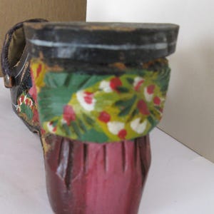 Peut inclure: Une figurine de chaussure en bois d&eacute;corative avec un talon et une semelle noirs. La partie sup&eacute;rieure est peinte d'une bande verte vive orn&eacute;e de motifs floraux rouges et blancs, tandis que le bas du talon est fini en rose fonc&eacute; uni.