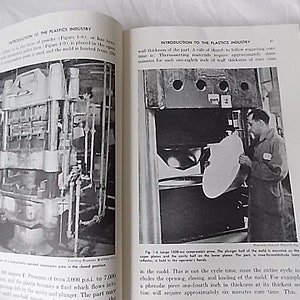 Peut inclure: Double page d'un livre ancien intitul&eacute; &laquo; Introduction &agrave; l'industrie des plastiques &raquo;. La page de gauche montre un sch&eacute;ma d'une presse &agrave; compression hydraulique. La page de droite montre un homme utilisant une grande presse.