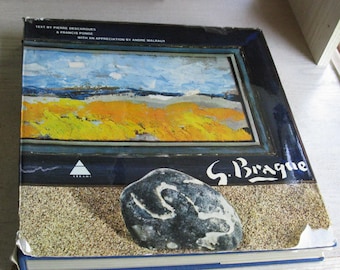 May include: A hardcover book titled G. Braque featuring a landscape painting with blue sky and yellow fields on the cover. The cover includes text by Pierre Descargues and Francis Ponge, an appreciation by Andre Malraux, and a dark stone on sand.