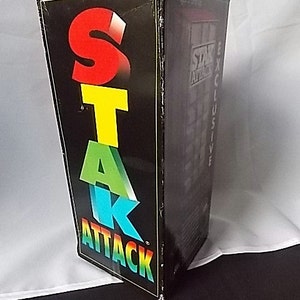 May include: A black box with the words "STAR ATTACK" in large, colorful letters. The letters are red, yellow, green, and blue. The box has the words "EXCLUSIVE" and "Ages 5 and up" printed on the side.