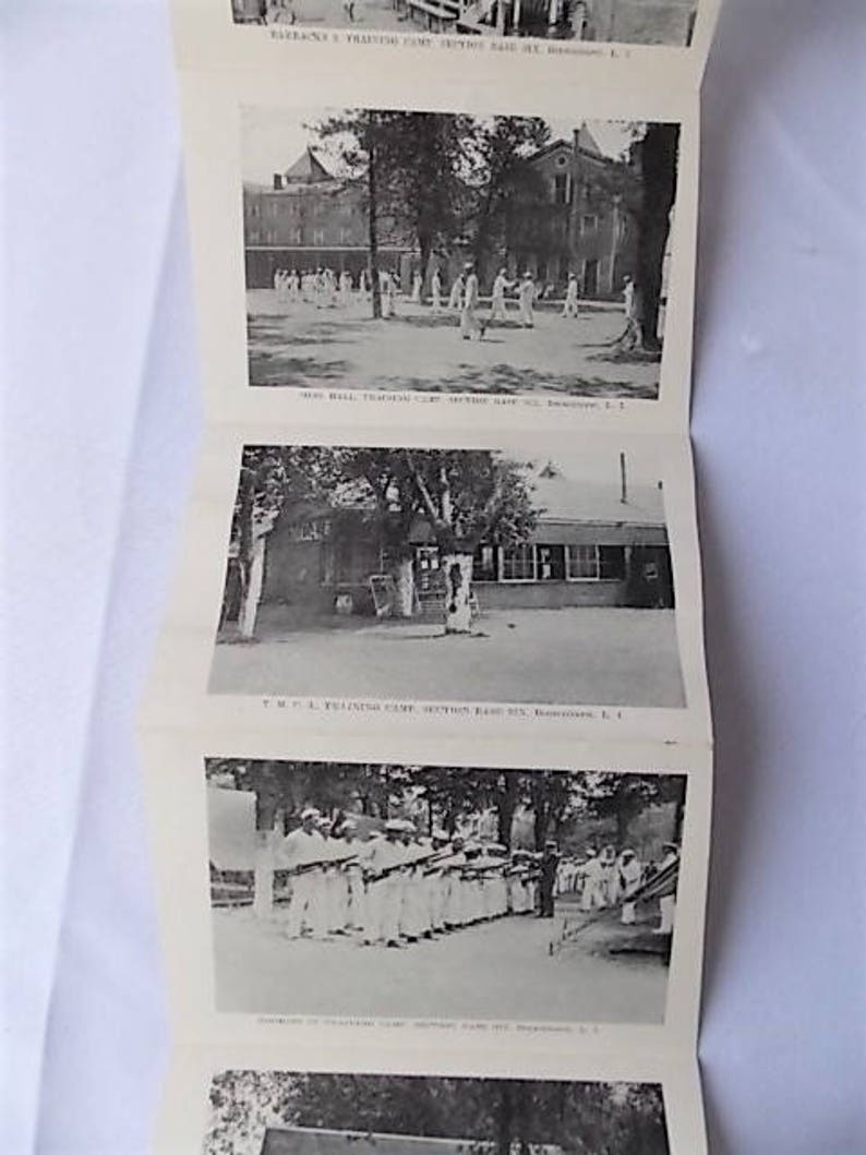 Może przedstawiać: Czarno-biała, zabytkowa broszura z kilkoma fotografiami obozu szkoleniowego. Zdjęcia przedstawiają osoby w mundurach, budynki i sceny plenerowe. Broszura jest złożona w harmonijkę.