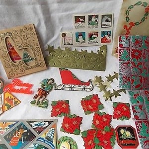 May include: A collection of vintage Christmas ephemera including a gold glitter card, a sheet of holiday stamps, a red sleigh cutout, various poinsettia die-cuts, metallic star shapes, and decorative paper sheets featuring festive holiday imagery.
