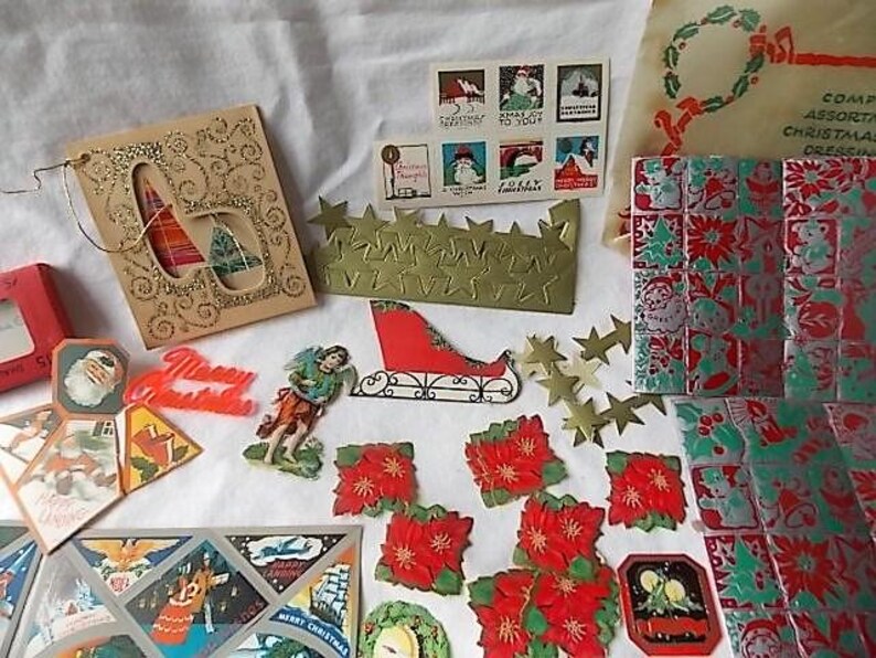 May include: A collection of vintage Christmas ephemera including a gold glitter card, a sheet of holiday stamps, a red sleigh cutout, various poinsettia die-cuts, metallic star shapes, and decorative paper sheets featuring festive holiday imagery.