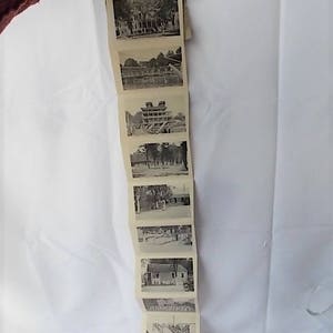 Może przedstawiać: Vintage pasek zdjęć w stylu harmonijki, przedstawiający osiem czarno-białych zdjęć budynk&oacute;w i krajobraz&oacute;w. Pasek jest trzymany przez rękę na białym tle. Zdjęcia wydają się pochodzić ze starszej epoki.