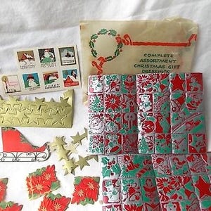 May include: A vintage Christmas gift dressing set including a printed paper envelope, a sheet of six holiday stickers, a gold star garland, a red and white sleigh cutout, and multiple sheets of red, green, and silver foil Christmas seals.
