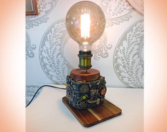 機械的な要素とコンパスのアクセントを備えたインダストリアルなスチームパンク風テーブルランプ