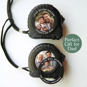 Puede incluir: Dos cintas métricas negras con fotos en el interior. Una dice "Loved Beyond Measure, Father's Day 2026." La otra dice "A Life Well Measured, The Legacy Continues." Un círculo verde dice "Perfect Gift for Dad."