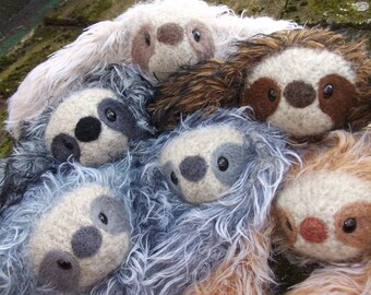 baby sloth with stuffed animal