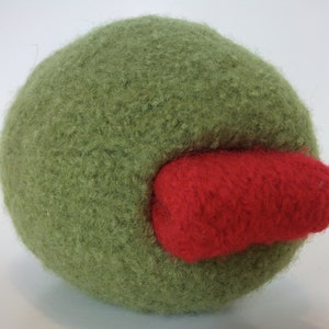 May include: A green fuzzy ball with a red fuzzy patch on the side.