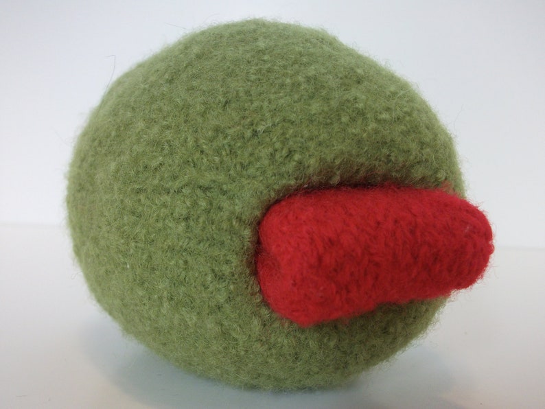 May include: A green fuzzy ball with a red fuzzy patch on the side.
