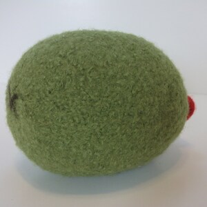 May include: A green felt ball with a red felt accent. The ball is soft and fuzzy.