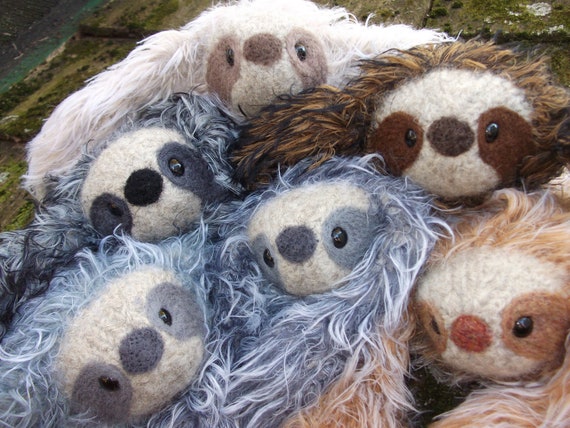 baby sloth hugging stuffed animal