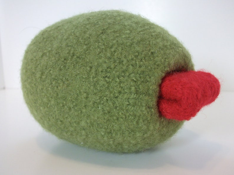 May include: A green plush olive with a red felt stem. The olive is a soft, cuddly toy.