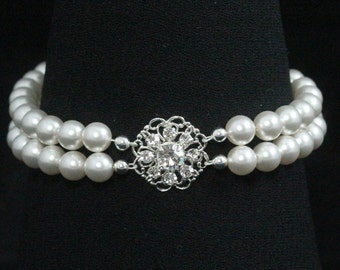 May include: A double strand pearl necklace with a silver rhinestone flower clasp.