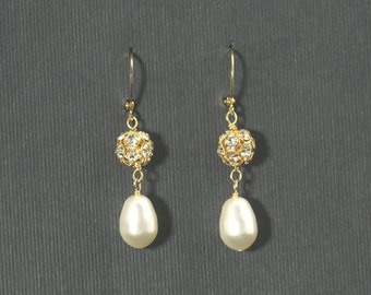 May include: A pair of gold dangle earrings with a pearl drop and a small crystal ball charm.
