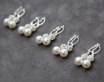 May include: Five pairs of silver earrings with a pearl and rhinestone design. Each earring features two white pearls and a cluster of clear rhinestones.