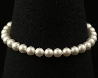 May include: A white pearl bracelet with a simple design. The bracelet is made of small, round pearls that are strung together on a thin string.