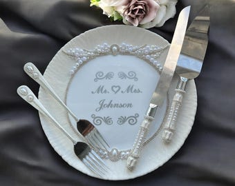 Bröllopstårtutskärset med personliga champagneglas, specialanpassad kniv, serveringsfat och tallrik, elegant mottagningsdekoration för brud och brudgum