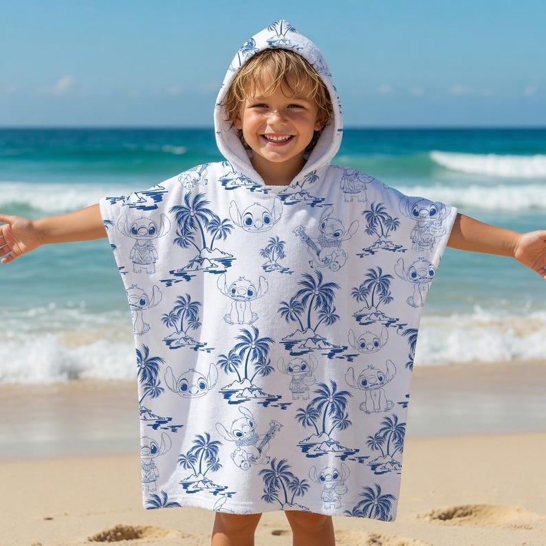 May include: A white hooded poncho towel featuring a repeating blue line art pattern of the character Stitch from Lilo & Stitch, interspersed with illustrations of tropical palm trees and island landscapes across the entire fabric surface.