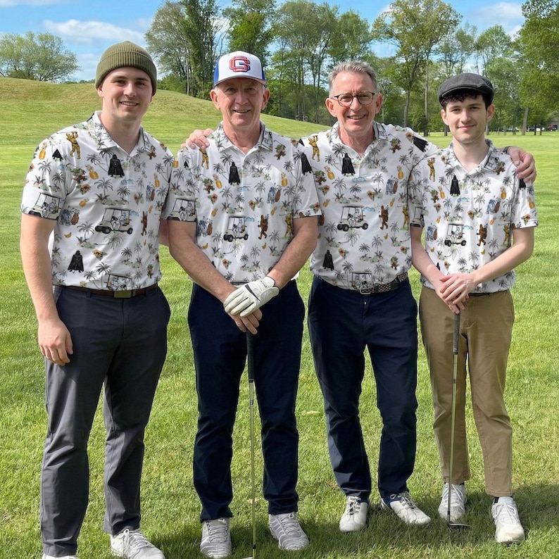 Pu&ograve; includere: Quattro persone in piedi su un campo da golf, che indossano polo bianche abbinate con una stampa tropicale. Le camicie presentano un motivo di personaggi dei cartoni animati, palme e golf cart. Indossano pantaloni e cappelli di vari colori.