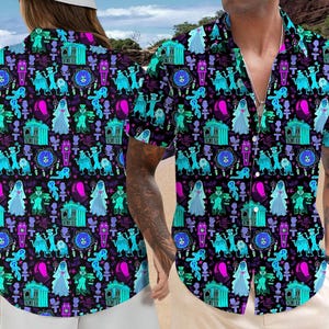 Puede incluir: Camisa de manga corta con botones y un patrón repetido de fantasmas de dibujos animados, carruajes y otros elementos espeluznantes en verde azulado, morado y rosa sobre un fondo negro. La camisa la lleva una persona en una playa.