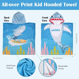 May include: A blue hooded kid's towel with a shark design. The front view shows a shark with the name "JAMES". The back view features a shark surfing. The towel is 24 inches (60.96cm) square and has a soft plush texture and reversible lining.