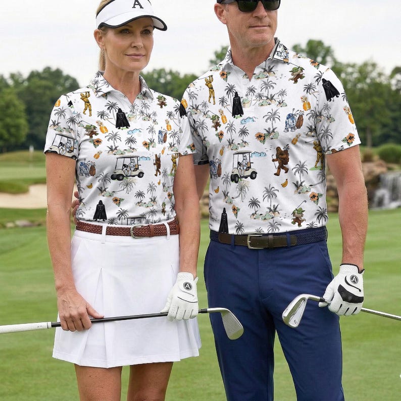Pu&ograve; includere: Una coppia indossa camicie da golf abbinate con una stampa a tema Star Wars. Le camicie sono bianche con un motivo di palme e personaggi di Star Wars. La donna indossa una gonna a pieghe bianca e una visiera. L'uomo indossa pantaloni blu.