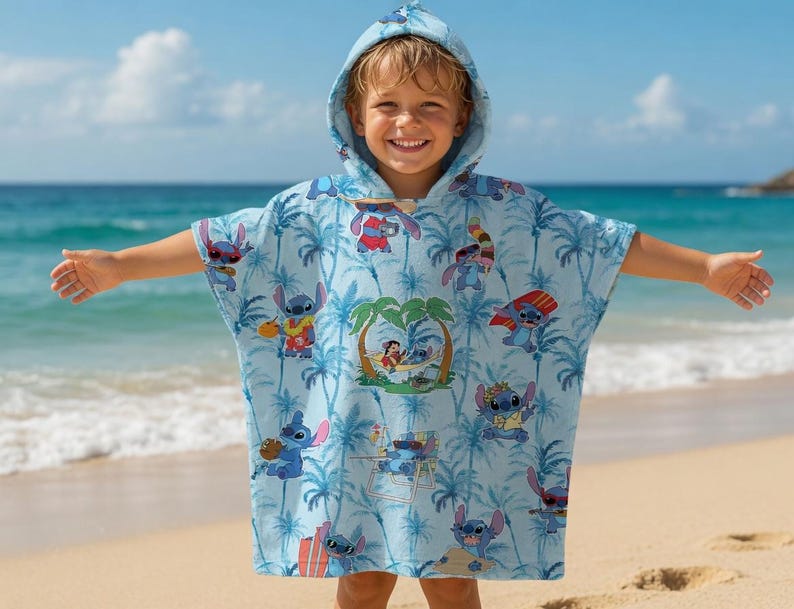 May include: A light blue hooded poncho towel featuring an all-over print of the character Stitch from Lilo and Stitch. The pattern includes palm trees and various illustrations of the blue alien character engaging in tropical beach activities.