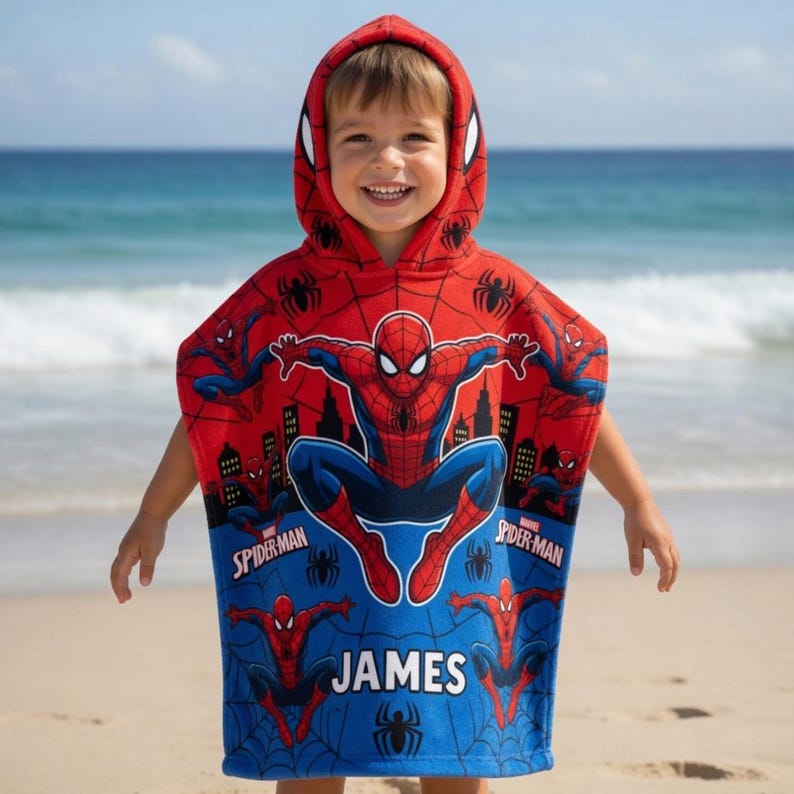 May include: A red and blue hooded towel featuring a Spider-Man graphic print, a black spider web pattern, and the name JAMES printed in white block letters. The towel includes a hood with Spider-Man eye designs and multiple character poses.