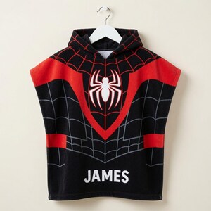 May include: A black hooded poncho towel featuring a red and black spiderweb pattern across the chest and shoulders. A large white spider emblem is centered on the chest, and the name JAMES is printed in white capital letters at the bottom hem.