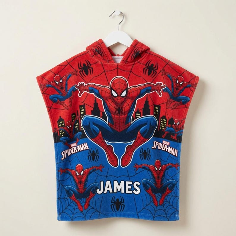 May include: A red and blue hooded poncho towel featuring a repeating Spider-Man graphic print, a black spider web pattern, a city skyline silhouette, the Marvel Spider-Man logo, and the name JAMES printed in white block letters on the front.