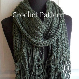 May include: A green crocheted scarf with fringe. The scarf is draped over a mannequin's neck. The text "Crochet Pattern" is visible on the scarf.