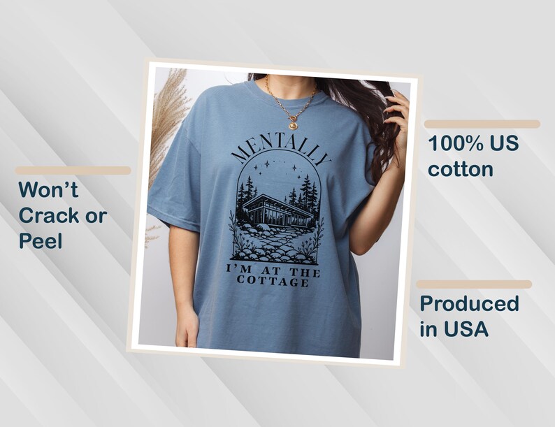 May include: A blue t-shirt with the text "MENTALLY I'M AT THE COTTAGE" in black. The graphic features a cabin scene with trees and stars. The shirt is made of 100% US cotton and is produced in the USA. The shirt is designed to not crack or peel.
