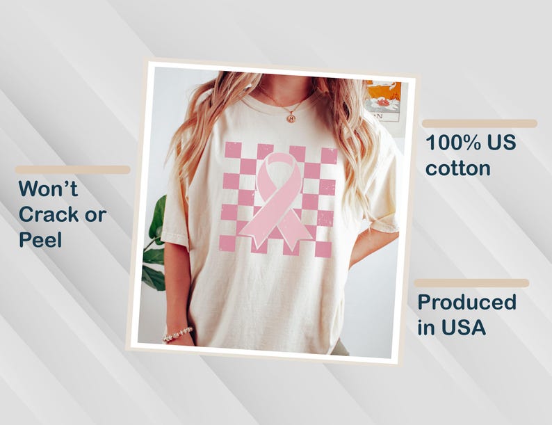 May include: A cream-coloured t-shirt with a pink ribbon design on a checkered pattern. Made from 100% US cotton and produced in the USA. The print is designed to resist cracking or peeling.