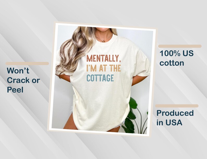 May include: Cream-colored t-shirt with the text "MENTALLY, I'M AT THE COTTAGE" in brown, blue, and orange. The shirt is made of 100% US cotton and is produced in the USA. The design is made to not crack or peel.