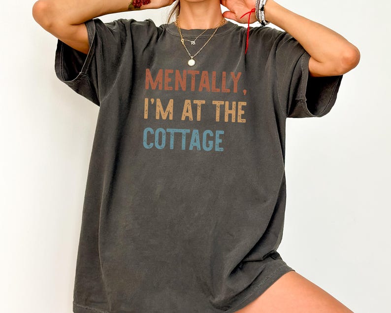 Unisex graphic shirt with mentally im at the cottage text inspired by hockey romance books, designed for booktok readers and lgbt sports romance fans.