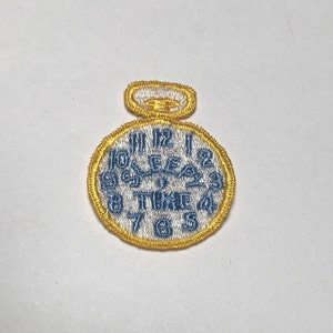 May include: A yellow and white embroidered patch of a pocket watch with the words "TIME" and numbers 1 through 12.