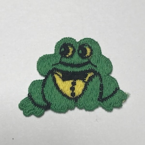 May include: Green felt frog applique with black eyes and a yellow bow tie.