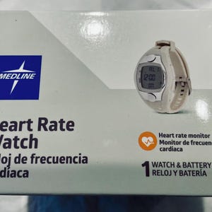 Pu&ograve; includere: Un cardiofrequenzimetro bianco e argento con display digitale &egrave; mostrato su una scatola. La scatola &egrave; bianca con il marchio "MEDLINE" e le parole "Heart Rate Watch" in inglese e spagnolo.