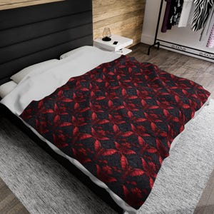 May include: A black and red patterned bedspread with a repeating design of red bat wings on a black background.