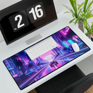 Pode incluir: Tapete de mesa retangular com um design vibrante de cidade neon, palmeiras e um carro. Um teclado e um rato brancos estão no tapete. Um monitor de computador mostra a hora: 14:16.