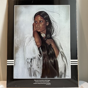 Op de afbeelding: Een schilderij van een indiaanse vrouw met lang zwart haar, die een witte, gefranst shawl draagt. De vrouw kijkt naar de zijkant en heeft een serieuze uitdrukking op haar gezicht. De achtergrond is lichtgrijs. Het schilderij bevat de tekst "May your moccasins make happy tracks in many snows and the rainbow always touch your shoulder. Indian Blessing."