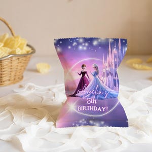 Pu&ograve; includere: Un sacchetto di patatine personalizzato con uno sfondo sfumato viola e rosa, con un'illustrazione di un castello. La borsa presenta due personaggi dei cartoni animati e il testo "Amelia's 5th BIRTHDAY!" stampato.