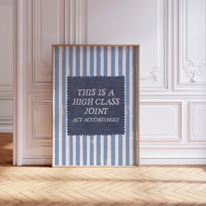 Pode incluir: Uma arte de parede retangular emoldurada com um fundo de listras verticais azul-claras e brancas. Centralizado, um quadrado azul-escuro texturizado com bordas serrilhadas contém o texto branco: THIS IS A HIGH CLASS JOINT ACT ACCORDINGLY.