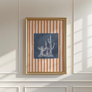 Peut inclure: Tableau encadré avec un carré bleu orné d'un dessin de cactus blanc. Le fond présente des rayures verticales orange et blanches. Le cadre doré ajoute une touche d'élégance à cette œuvre d'art sur le thème du désert.