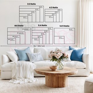 May include: A size guide chart displaying various aspect ratios including 3:2, 4:3, ISO, 5:4, and 14:11 with specific dimensions in inches and centimeters. The chart is positioned above a white sofa with blue pillows and a wooden coffee table.