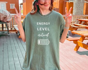May include: A green t-shirt with the text "ENERGY LEVEL critical" and a battery icon with an empty charge bar.