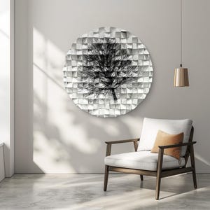 May include: A round, white wall art piece with a black and white tree design. The artwork is made of small, square blocks arranged in a circular pattern. A modern armchair with a white cushion and an orange pillow is in the foreground.