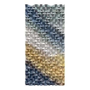 Puede incluir: Una pieza de arte mural rectangular de madera con un diseño degradado. La obra presenta un mosaico de pequeños bloques de madera cuadrados en tonos de azul, gris, blanco y dorado. Los bloques están dispuestos para crear un efecto texturizado y tridimensional.